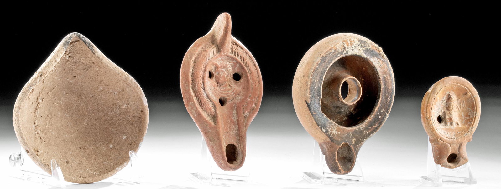 Lot of 4 Oil Lamps - Holy Land, Roman & Greek: **Originally Listed At $400** First, Ancient Near East, Holy Land, Middle Bronze Age I-II, ca. 2200 to 1750 BCE. A single-spouted pottery lamp made from a creamy colored clay and hand-molded, with a p