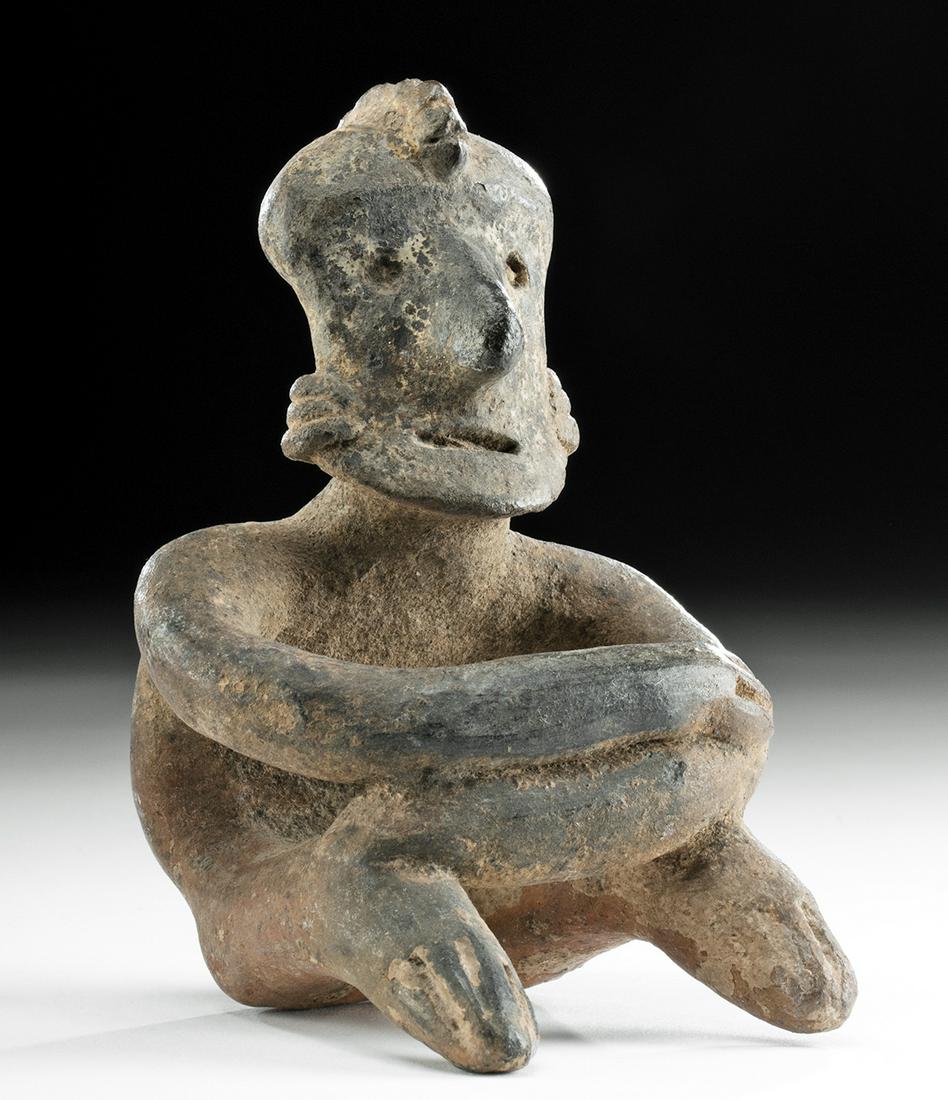 Nayarit Redware Seated Figure: **First Time At Auction** Pre-Columbian, West Mexico, Nayarit, ca. 300 BCE to 300 CE. A hand-built pottery figure seated with arms crossed atop bent knees. The head is raised in an attentive position