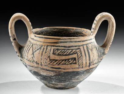 Greek Geometric Pottery Kantharos, ex-Royal Athena: Ancient Greece, Athens, Geometric Period, ca. 8th century BCE. A gorgeous wheel-thrown pottery kantharos with a planar base, a wide apple-shaped body with a tapered shoulder, a thin rim, and a pair