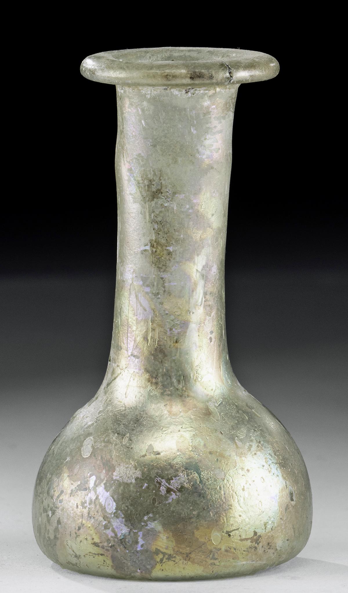 Miniature Roman Glass Flask - Amazing Iridescence: **First Time At Auction** Roman, Imperial Period, ca. 1st to 3rd century CE. A miniature vessel comprised of glass that while green in coloration is covered with amazing iridescence of golden and rain