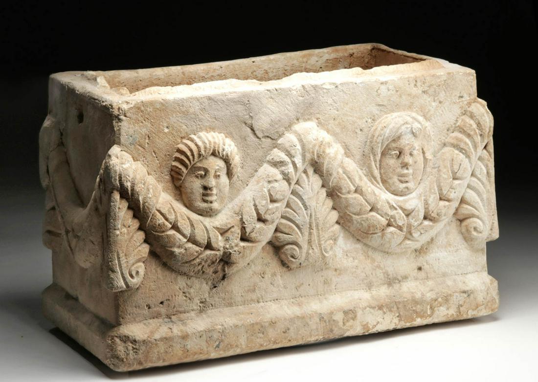 Roman / Byzantine Marble Ossuary - Cherubs, Acanthus: Late Roman / Early Byzantine Period, ca. 5th to 7th century CE. A handsome marble casket, rectangular in profile and carved to serve as an ossuary. The exterior front is decorated with a motif of two 