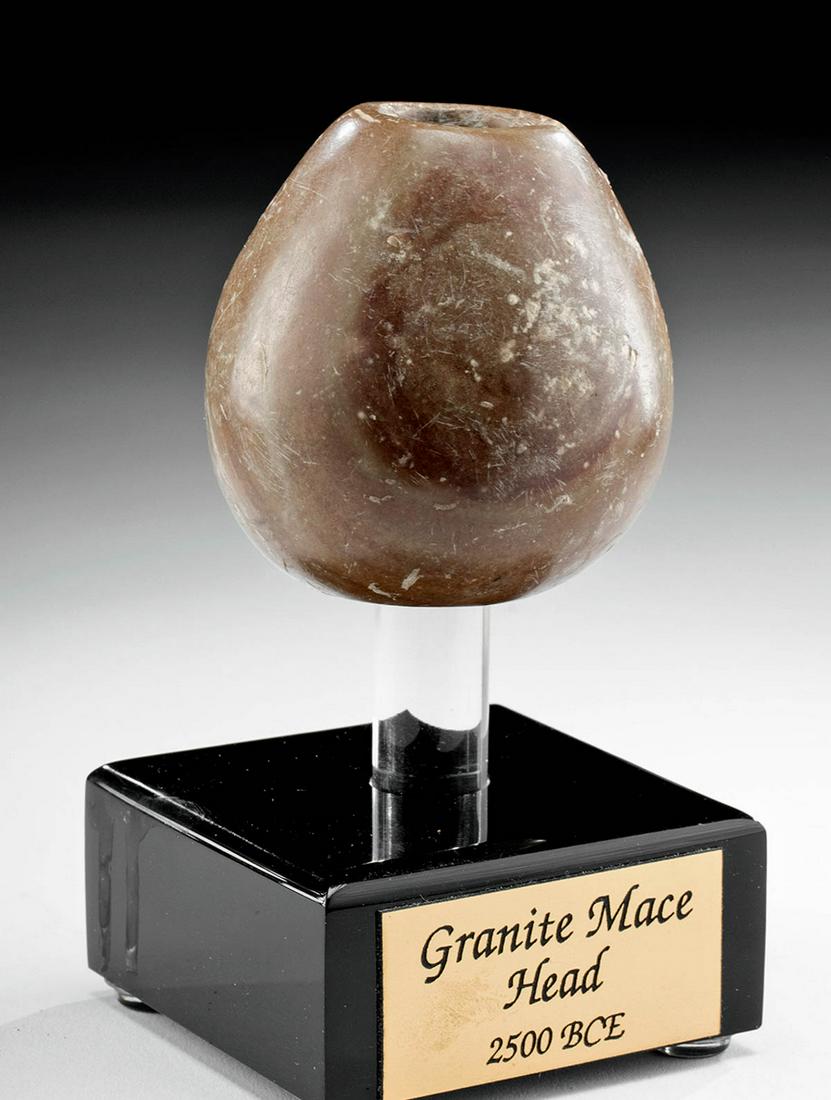 Egyptian Old Kingdom Pink Stone Mace Head: Egypt, Old Kingdom, Dynasties 3 - 6, ca. 2500 BCE. Beautiful highly polished stone mace head of an unusual stone with distinct pink and tan highlights. Typical piriform shape with central shaft hole, 
