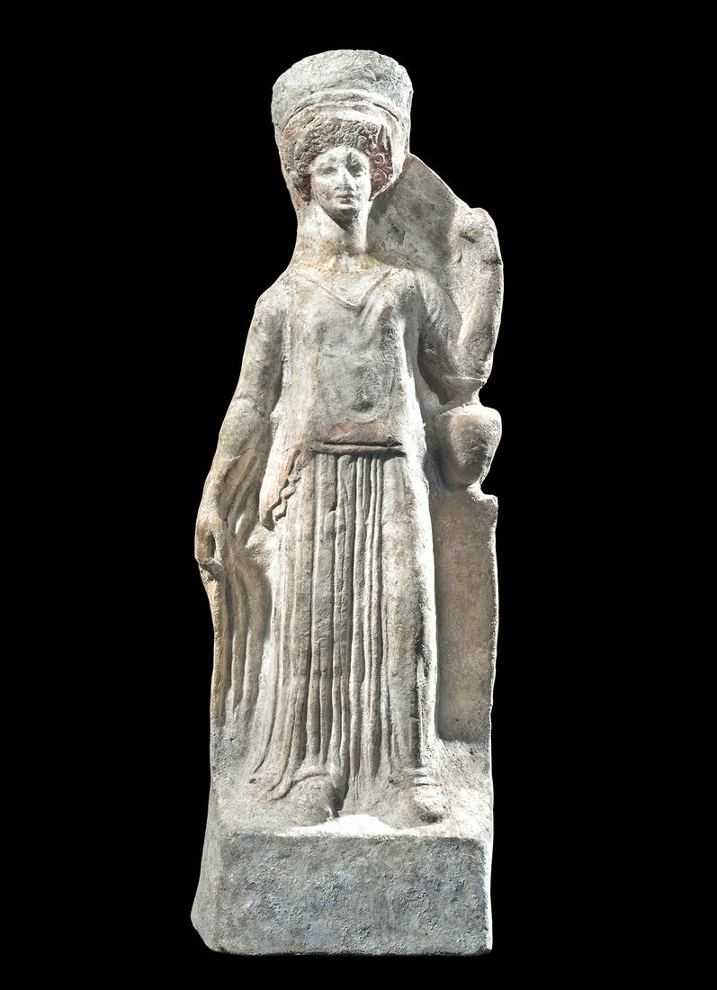 Tall Canosan Pottery Female Votive Figure: Magna Graecia, Southern Italy, Apulia, Canosa, ca. 3rd century BCE. A tall mold-made earthenware votive figure depicting a female goddess who is standing in classic contrapposto pose with her right le