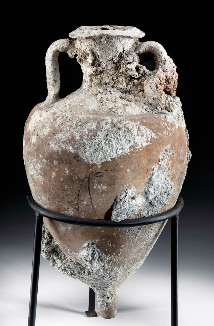 Roman Pottery Twin Handled Sea Salvage Amphora: Roman Empire, 1st to 3rd century CE. Quintessential terracotta transport amphora with piriform body tapering to a pointed base. Twin handles from shoulders to the thick rim, surface now covered with e