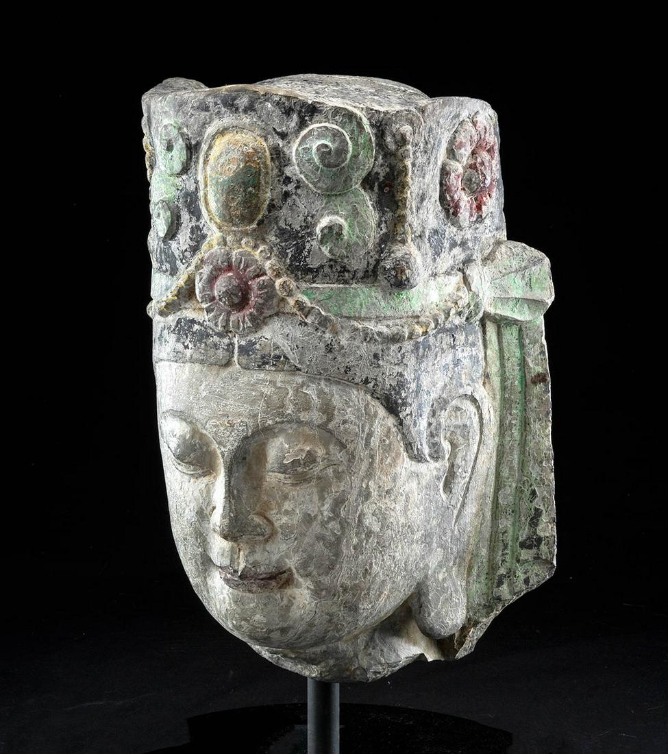 Chinese Ming Dynasty Stone Bodhisattva Head: East Asia, China, Ming Dynasty, ca. 1368 to 1644 CE. A striking hand carved and painted stone head depicting a bodhisattva donning an elaborate crown adorned with spiraling tendrils, a lovely beaded b