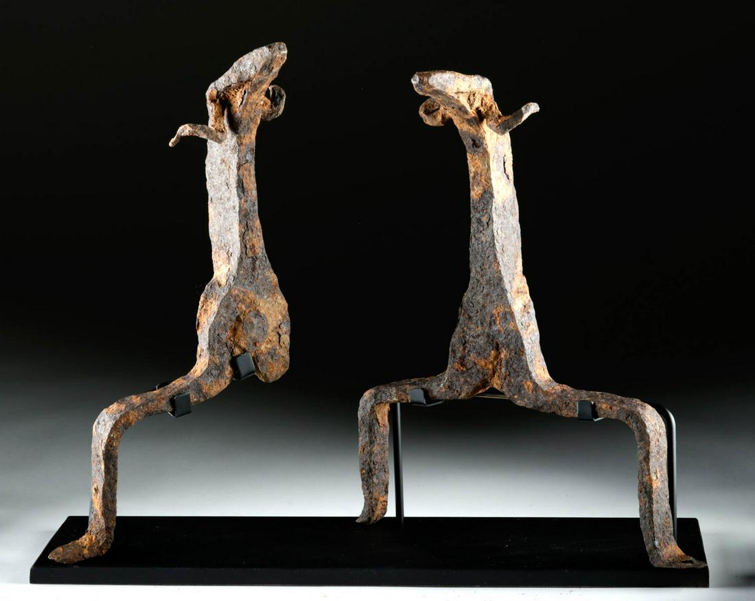 7th C. Anglo-Saxon Iron Andirons w/ Ram Heads (pr): Northern Europe, Anglo-Saxon or possibly other Germanic culture, ca. 7th to 9th century CE. A fine pair of cast-iron andirons used to support large logs within a grand hearth. Each andiron boasts a st