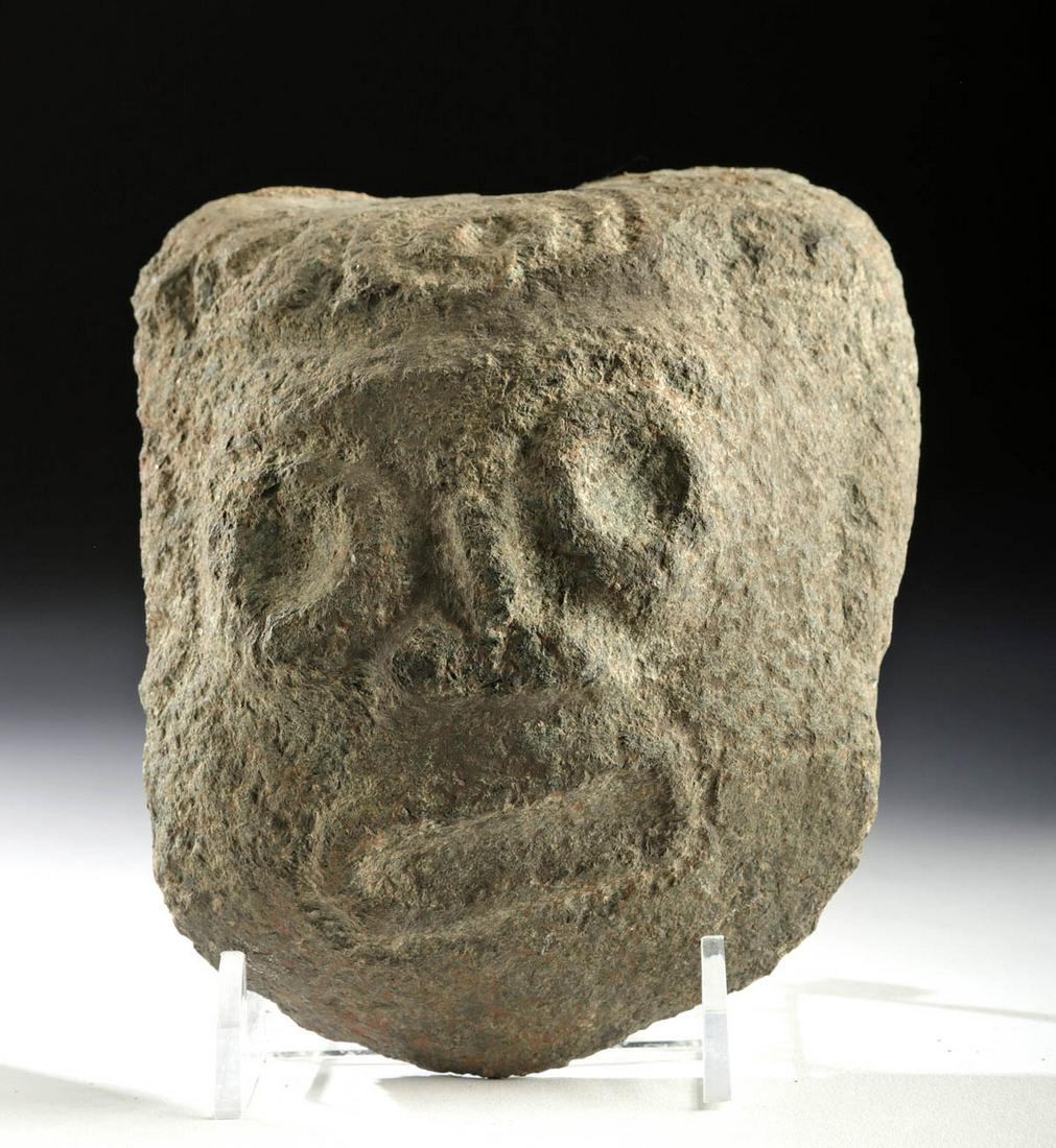 Taino Arawak People Volcanic Stone Face: Pre-Columbian, Caribbean/Florida, Arawak People, Taino, ca. 15th century CE. An anthropomorphic face carved from a rough volcanic stone with deep, wide eyes ringed with thick lids, a wide, open mouth 