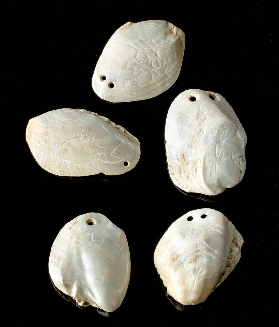 Prehistoric Mississippian Engraved Mussel Shell Amulets: Native American, Alabama, Morgan County, Mississippian, ca. 1100 to 1500 CE. A mesmerizing ensemble of five freshwater mussel shell amulets/gorgets with mother of pearl iridescence, each with Hemphill