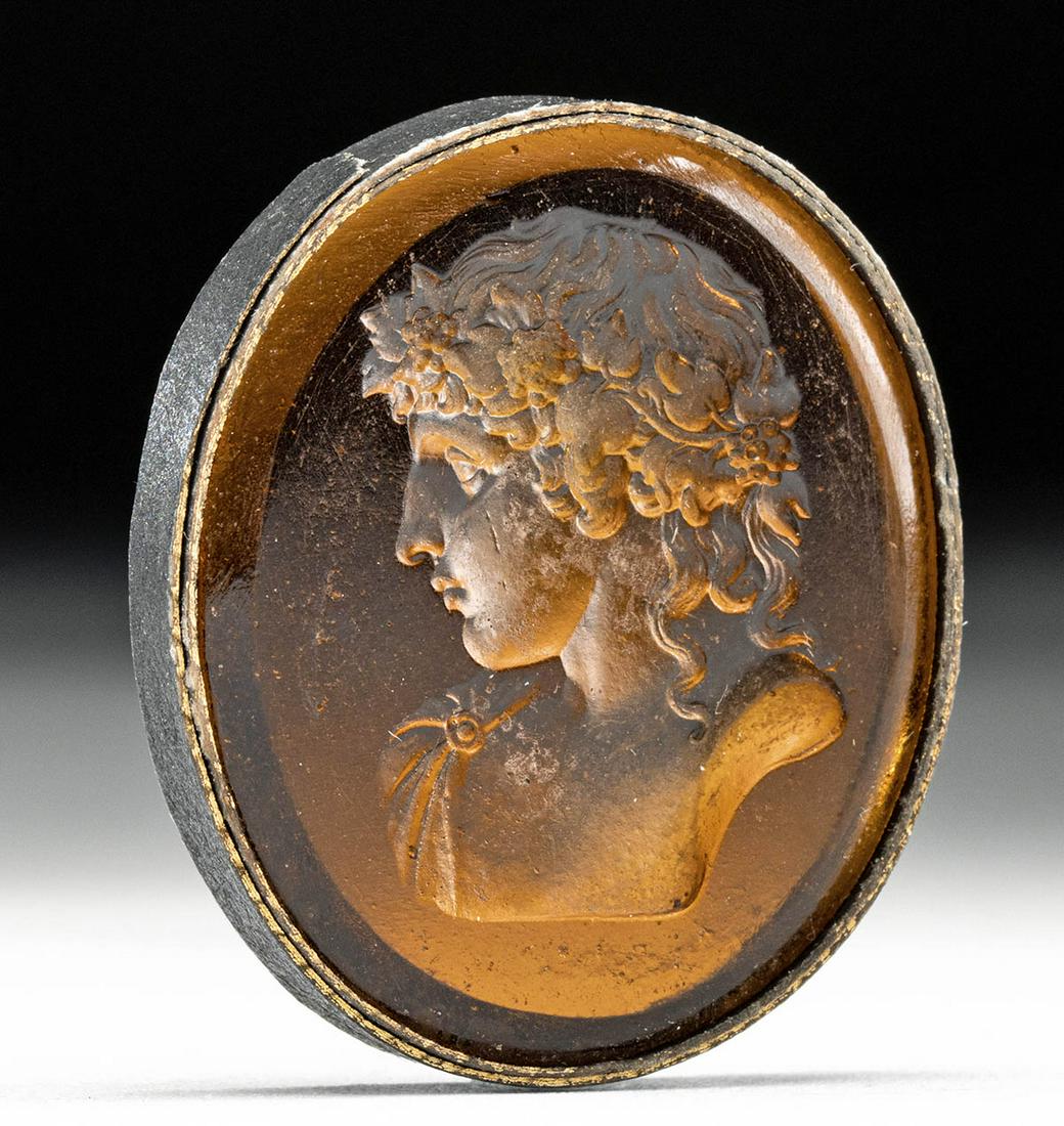 Neoclassical Glass Intaglio - Young Dionysos / Bacchus: Northern Europe, Neoclassical period, ca. 18th to 19th century CE. A beautiful golden yellow glass intaglio depicting a bust of a youthful Dionysos/Bacchus in profile with idealized features crowned b