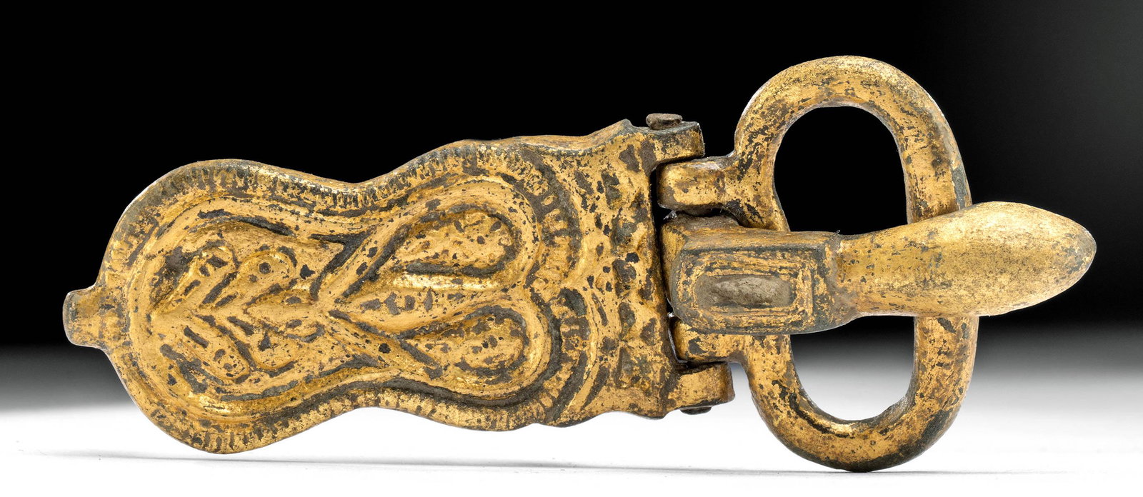 7th C. Byzantine 15K+ Gilt Bronze Buckle: Ancient Near East, Holy Land, Byzantine Empire, ca. 7th to 10th century CE. A beautiful buckle of an elongated form that is cast from bronze via the lost wax (cire perdue) technique and enrobed in a t