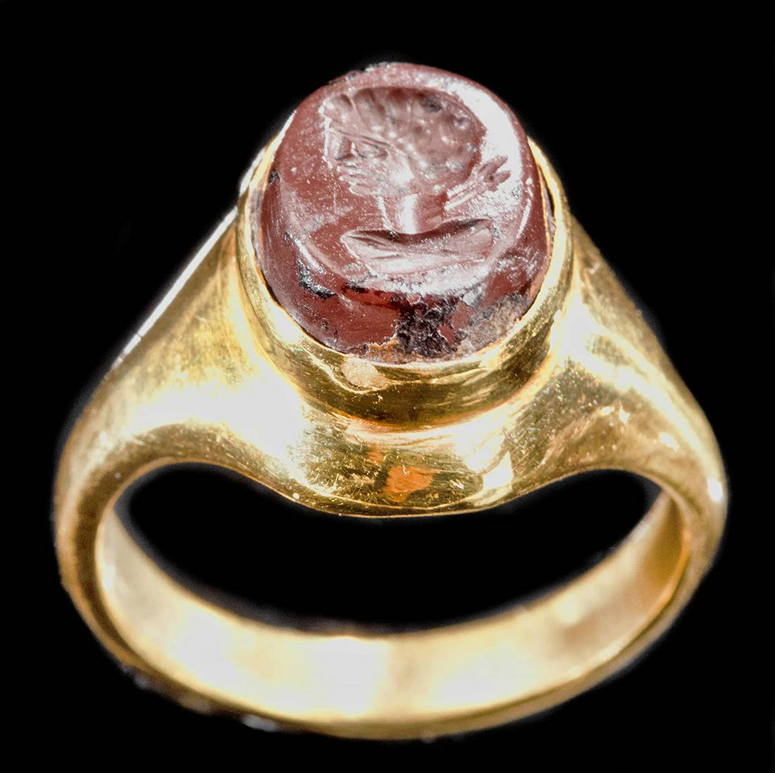 22K+ Gold Ring w/ Ancient Roman Jasper Intaglio: Roman, Imperial Period, ca. 2nd to 3rd century CE. A beautifully preserved intaglio of an ovoid form, hand-carved from crimson-hued jasper. The intaglio has a slightly beveled periphery, and the flat 