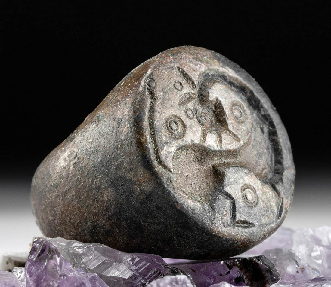 Large 12th C. Islamic Bronze Ring w/ Abstract Avian: Medieval Near East, Holy Land, Islamic, ca. 12th to 14th century CE. A sizable ring, cast from bronze via the lost wax technique, that depicts a highly abstract avian creature incised atop the face. T