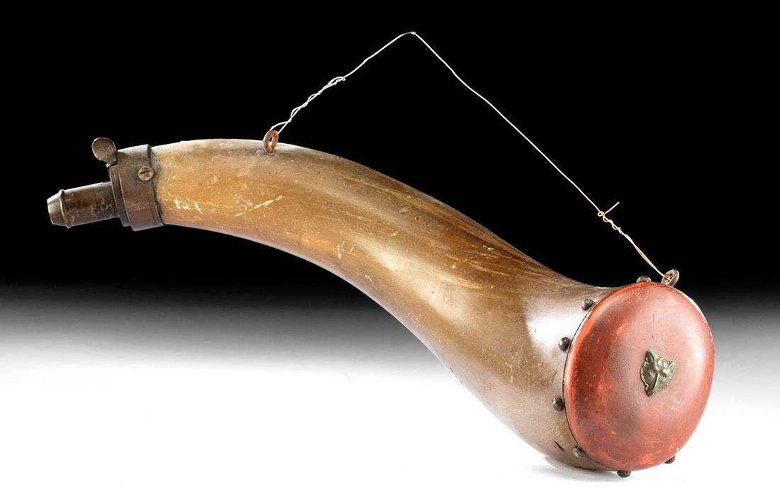 18th C. American Powderhorn w/ Brass Wolf: North America, American, ca. later 18th century CE. A fine example of a powderhorn with a brass tip and painted red wood cap with a brass decorative pin in the form of a wolf head. Powderhorns were an