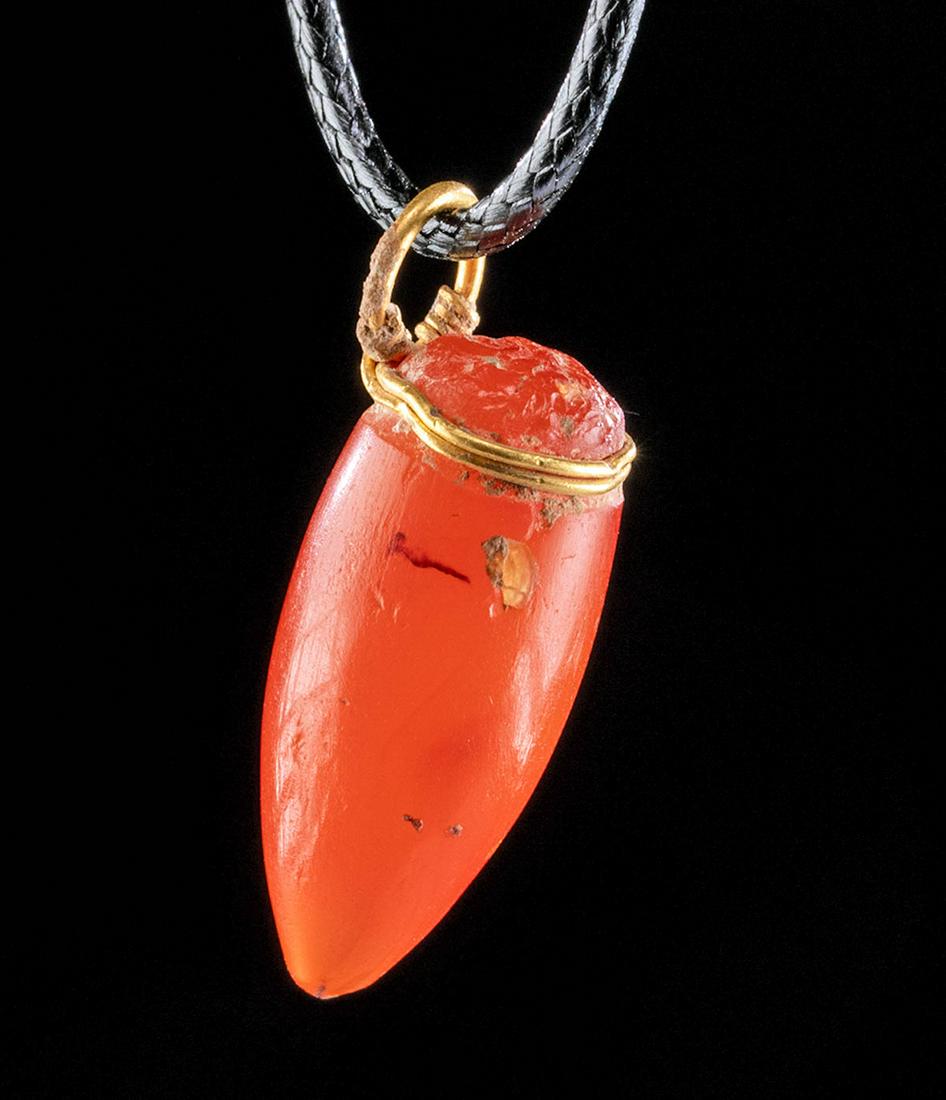 Romano-Egyptian Carnelian Pendant / 22K+ Gold: Roman-controlled Egypt, Alexandria, late Ptolemaic to early Roman period, ca. 1st century BCE to 1st century CE. A gorgeous pendant of a conical form that is hand-carved from vermilion-hued carnelian.