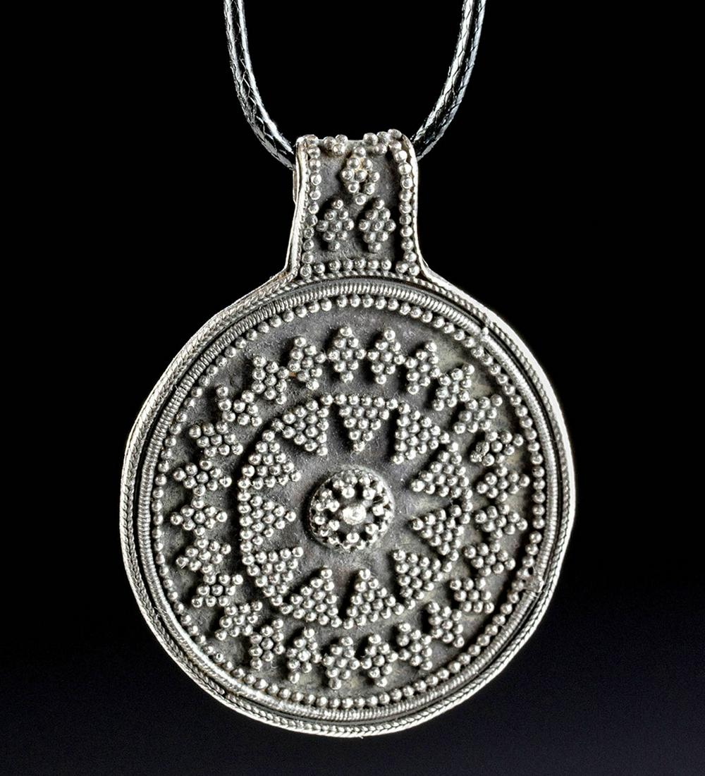 9th C. Viking Silver Granulated Bracteate Pendant: Northern Europe, Scandinavia, Viking or Norse culture, ca. 9th to 10th century CE. A stunning bracteate pendant formed from 97.5% silver consisting of a hammered discoid body with a beaded filigree bo