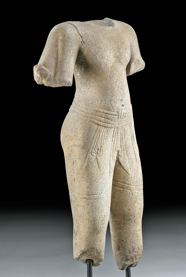 11th C. Cambodian Khmer Stone Sculpture of Young Man: Southeast Asia, Khmer Empire, Angkor Wat style, ca. 11th to 12th century CE. A sensual stone carving of a young man with an athletic torso. He is carved standing in the samabhanga position, wearing a 