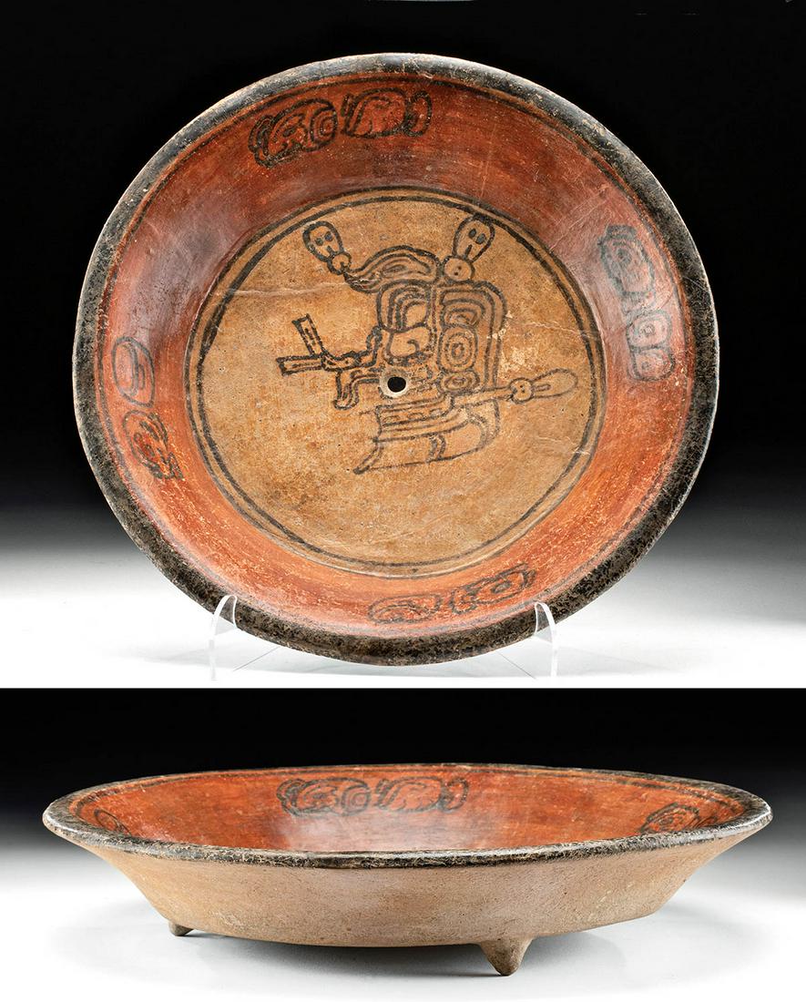 Maya Pottery Bowl w/ Skull and Kill Hole: Pre-Columbian, Late Classic Maya, ca. 550 to 900 CE. An incredible terracotta plate, richly decorated, with a "kill hole" in tondo. The iconography of the bowl is centered on a skull in tondo, with fo