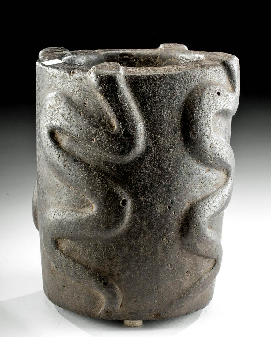 Fabulous Mapuche Stone Vessel with Snakes: Pre-Columbian, northern Chile or Argentina, Mapuche people, ca. 1500 CE. An elegant, finely carved stone vessel of a cylindrical form with four snakes slithering up the exterior walls, their serpentin
