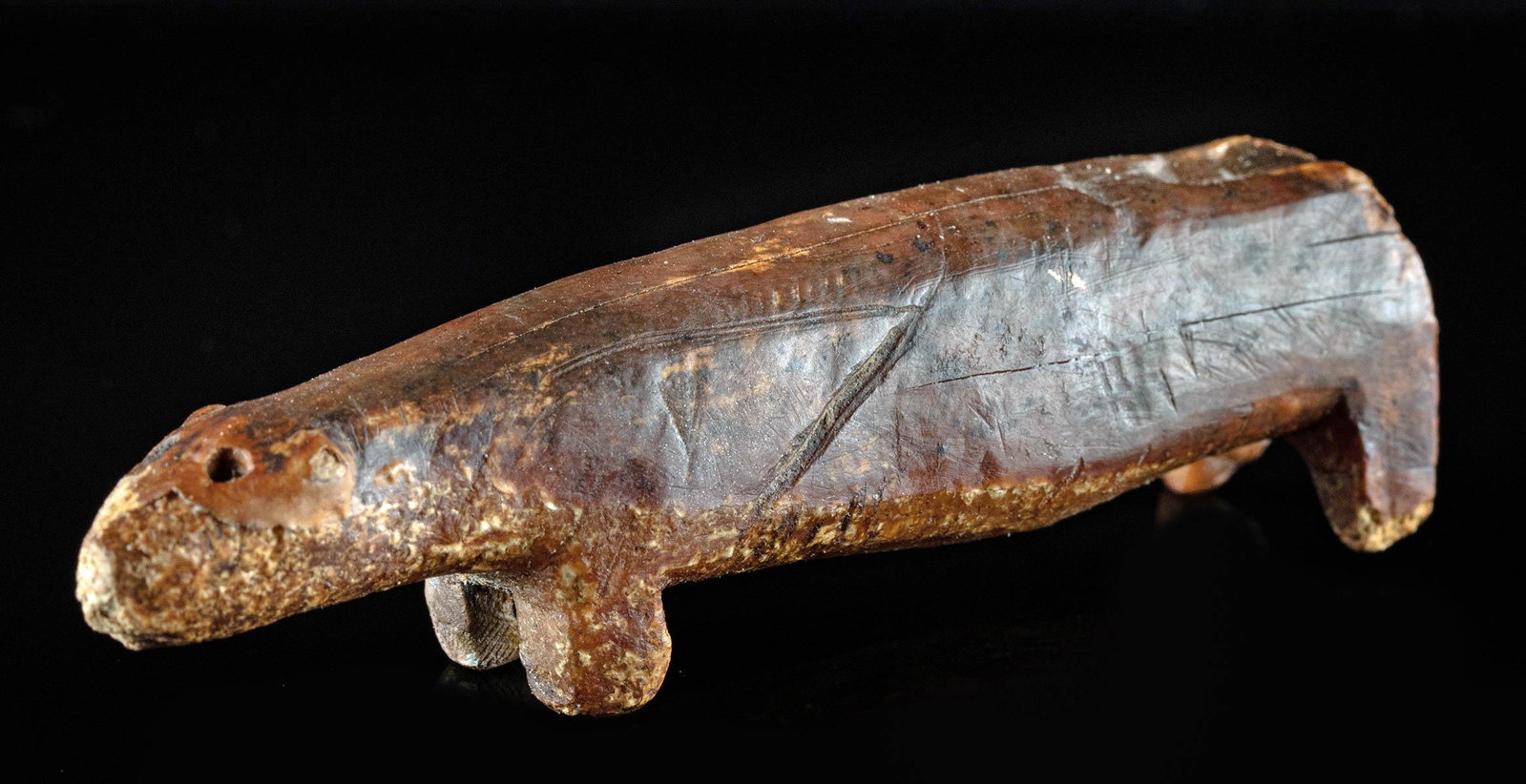 Ancient Inuit Carved Walrus Tusk Amulet - Bear: Native American/First Nations, Inuit, ca. 1000 to 1600 CE. A striking carved walrus tusk figure of a bear, with an elongated body, short, nub-like legs, and a powerful head with delineated ears. Age h
