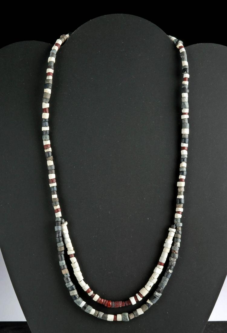 Sumerian Faience & Stone Beaded Necklace: Ancient Near East, Sumer, ca. 3rd to 2nd millennium BCE. An elegant and attractive necklace comprised of dozens of petite cylindrical beads shaped from chalky-white faience, dark-grey stone, and warm 