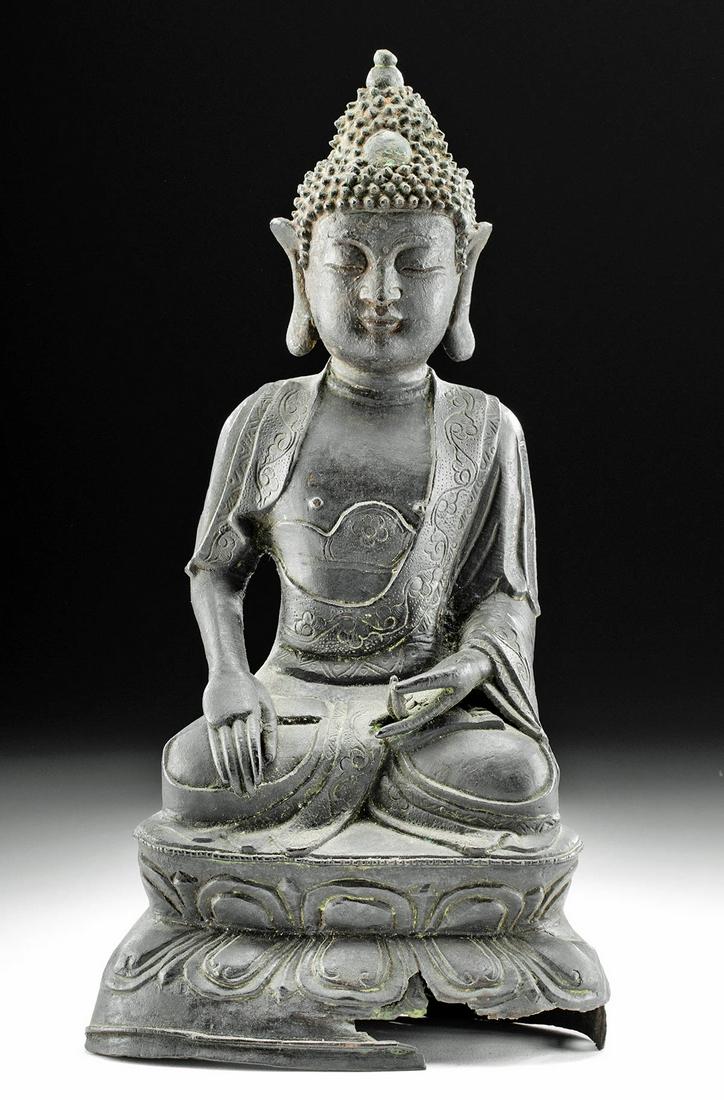 Chinese Ming Dynasty Bronze Seated Buddha Full Lotus: East Asia, China, Ming Dynasty, ca. 1368 to 1644 CE. A cast bronze statue of Buddha sitting in a full lotus pose atop a tiered lotus base. Buddha holds his hands in the Bhumisparsa mudra indicative of