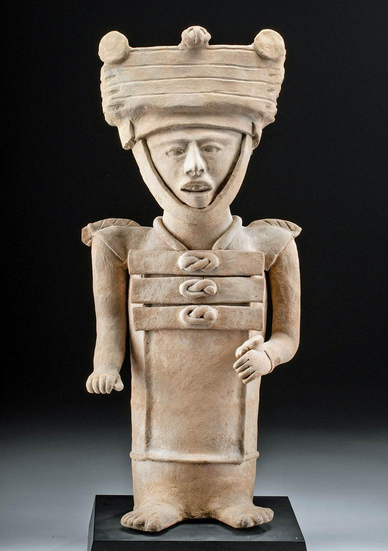 Monumental Veracruz Pottery Standing Dignitary Figure: Pre-Columbian, Mexico, Veracruz, ca. 400 to 700 CE. Impressively sizeable and finely handbuilt, a hollow-form terracotta statue of a standing male dignitary wearing a tunic-like garment with pronounce
