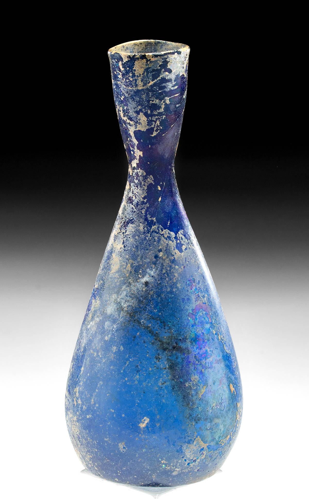 Roman Glass Bottle - Cobalt Color: Roman, early Imperial Period, ca. 1st to early 2nd century CE. A beautiful glass bottle that is free-blown from semi-translucent glass of a wondrous cobalt-blue color. The piriform vessel features a c