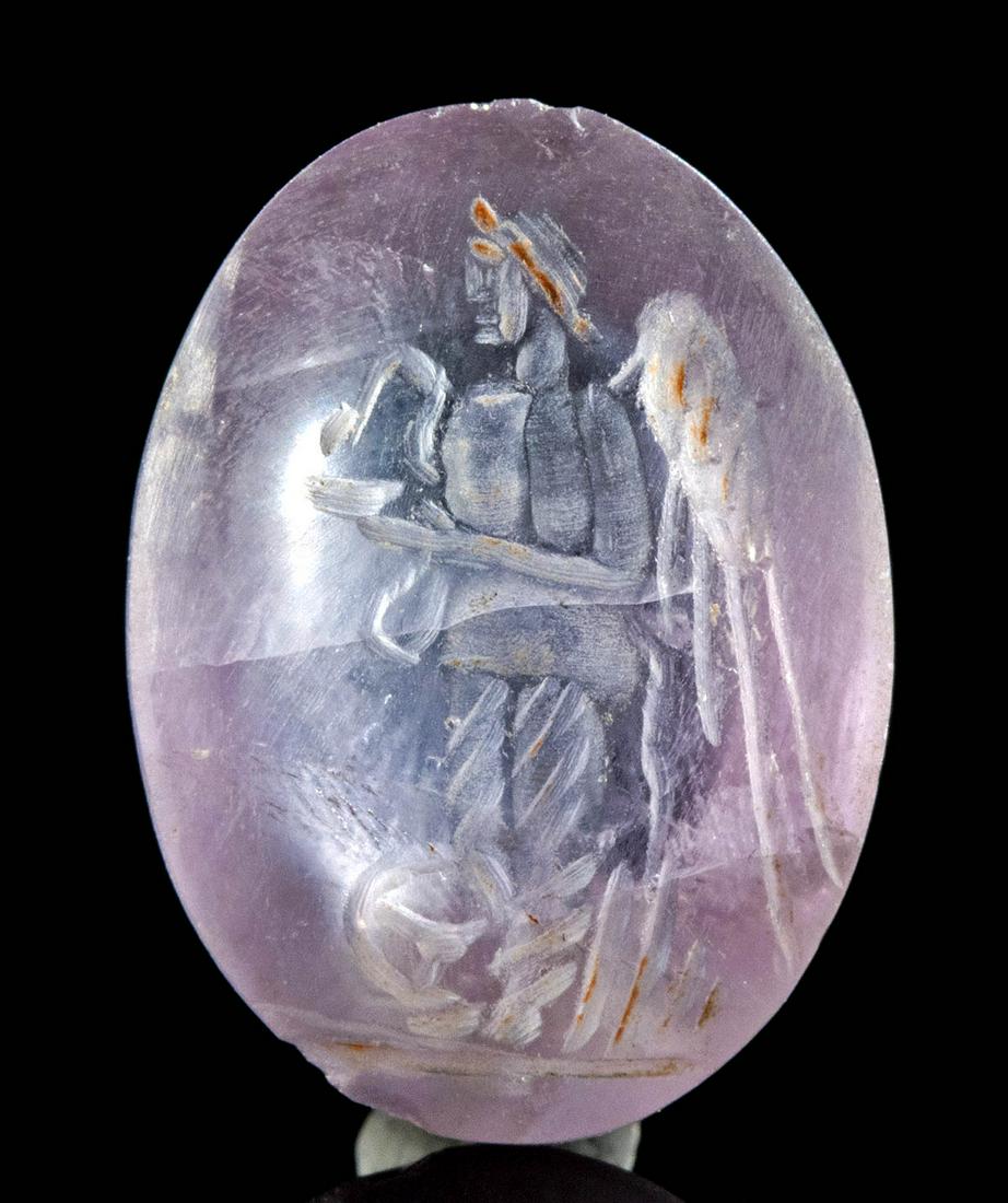 Roman Amethyst Cabochon Intaglio w/ Pantheistic Deity: Roman, Imperial Period, ca. 1st to 3rd century CE. A stunning oval amethyst cabochon intaglio of brilliant violet hues, finely engraved with a pantheistic deity presenting attributes from a number of 