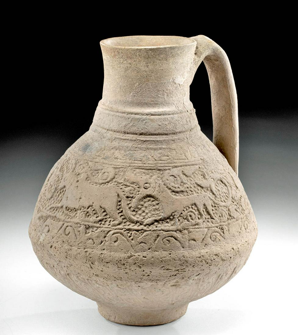 12th C. Ghurid Ceramic Pitcher w/ Zoomorphic Scene: Central Asia, central Afghanistan, Jam in Ghur province, Ghurid Dynasty, ca. 12th to 13th century CE. A wheel-thrown pottery pitcher with a squat foot, a broad piriform body that tapers to a cylindric