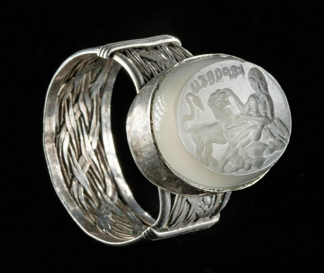 Silver Ring w/ Roman Quartz Intaglio, Woman, Lion: Roman, Imperial Period, ca. 1st to 4th century CE. A gorgeous intaglio carved from a fragment of translucent quartz depicting a reclining woman reaching out towards an intimidating lion. The woman exh