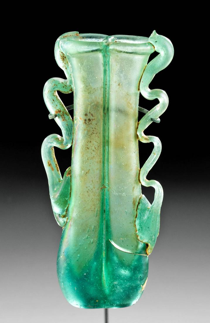 Roman Glass Double Unguentarium: Roman, Imperial Period, ca. 1st to 3rd Century CE. A gorgeous Roman unguentarium with rigaree that delicately ribbons down each slender side. This is a free-blown double unguentarium that is composed