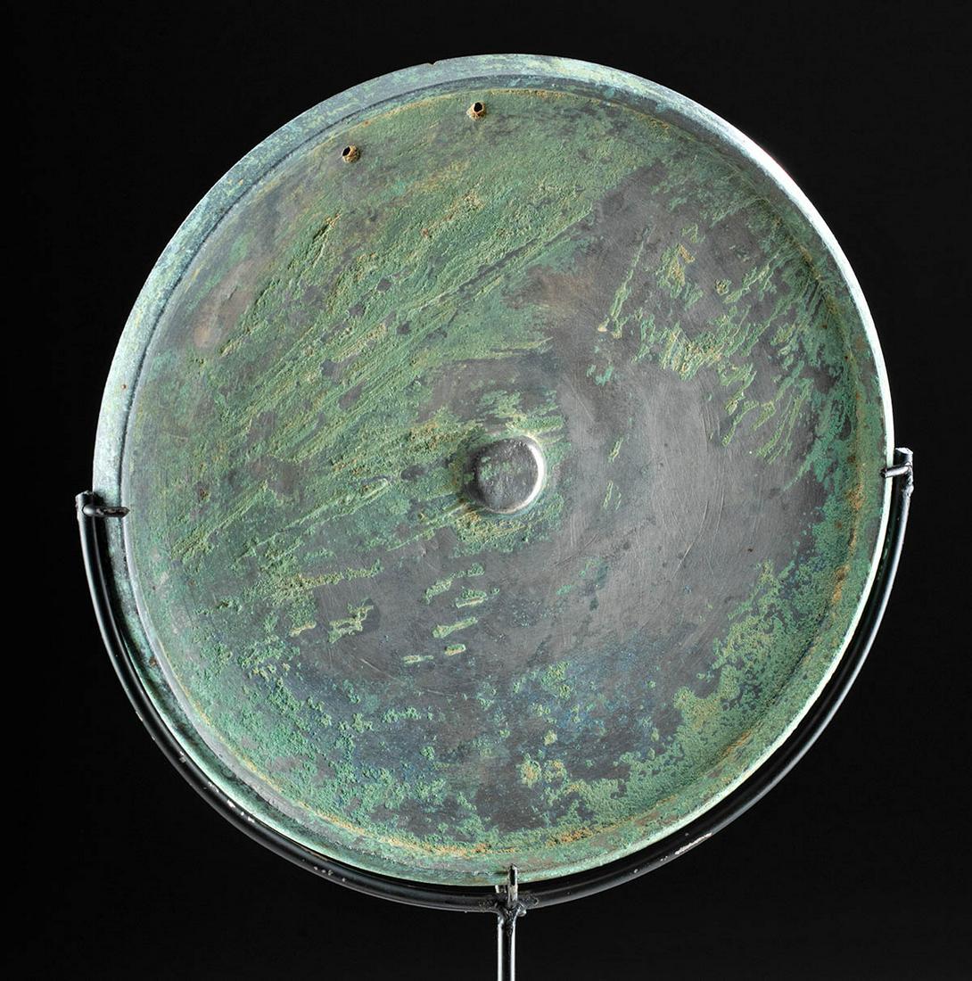 9th C. Khmer Bronze Mirror w/ Great Patina: Ancient Southeast Asia, Cambodia, Khmer Empire (Angkor culture), ca. 800 to 1300 CE. A cast-bronze mirror of a discoid form with a raised rim and a protruding central nodule. The obverse face bears lu