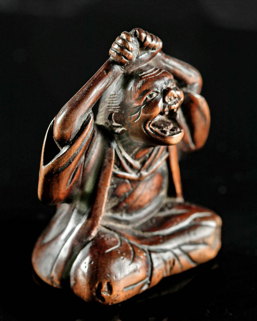 19th C. Japanese Boxwood Netsuke - Daruma: **First Time At Auction** East Asia, Japan, Meiji Period, ca. 1868 to 1912 CE. A whimsical dark boxwood netsuke with heavily detailed, realistic carving on all sides, depicting the figure of Daruma, t