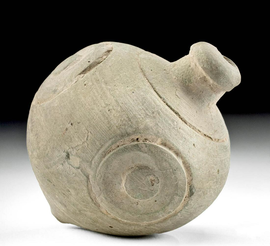 Byzantine Pottery Hand Grenade w/ Circular Motif: Ancient Near East, Holy Land, Byzantine Empire, ca. 10th to 12th century CE. A mold-formed pottery hand grenade exhibiting an acorn-shaped body with a tapered lower tip, a rounded shoulder, and a prot