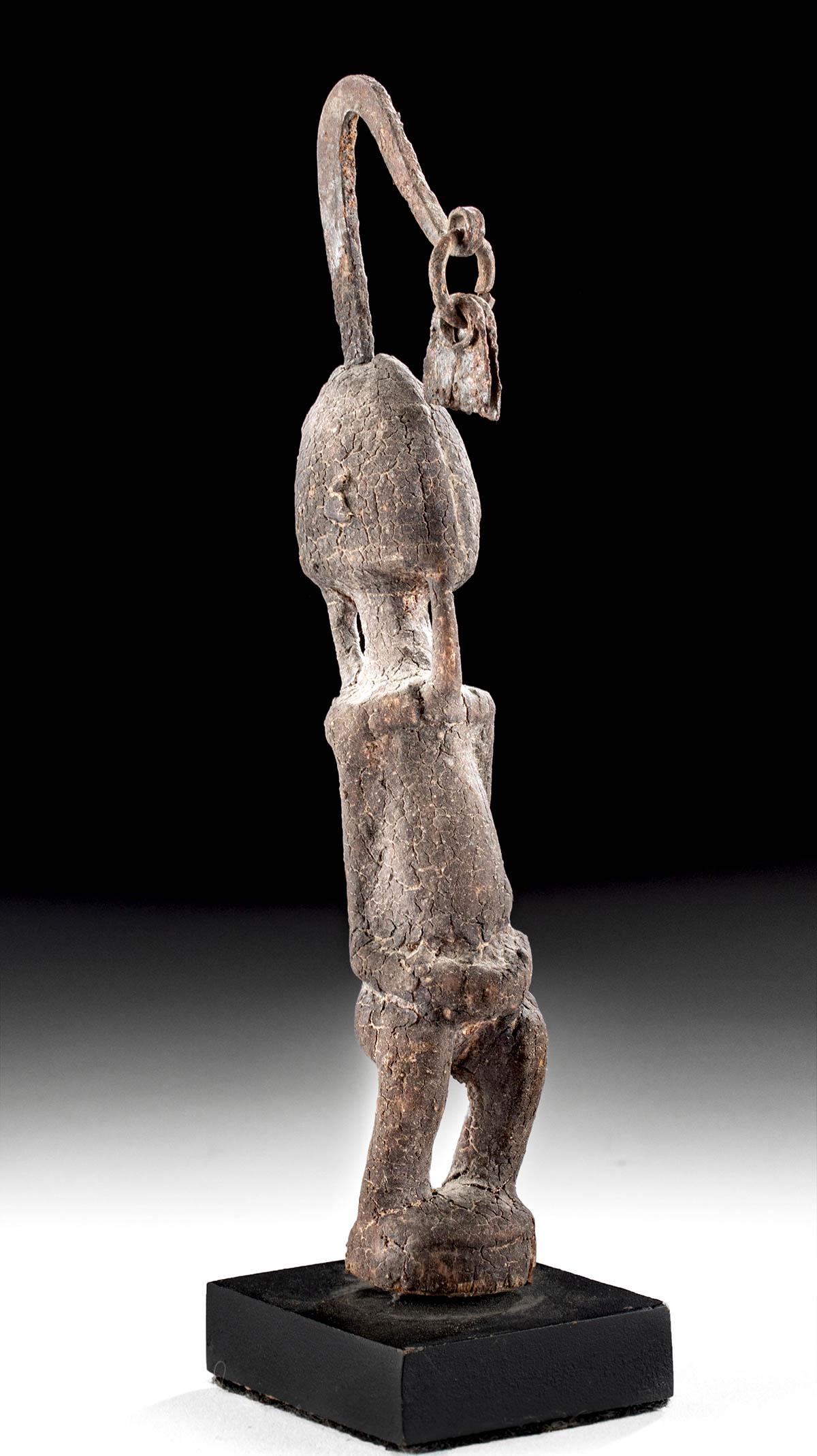 20th C. Mali Dogon Wood & Iron Ancestor Figure: West Africa, Mali, Dogon peoples, ca. early to mid-20th century CE. A hand-carved wooden ancestor figure standing with a slightly backwards lean atop an integral circular platform. Slender arms trace 
