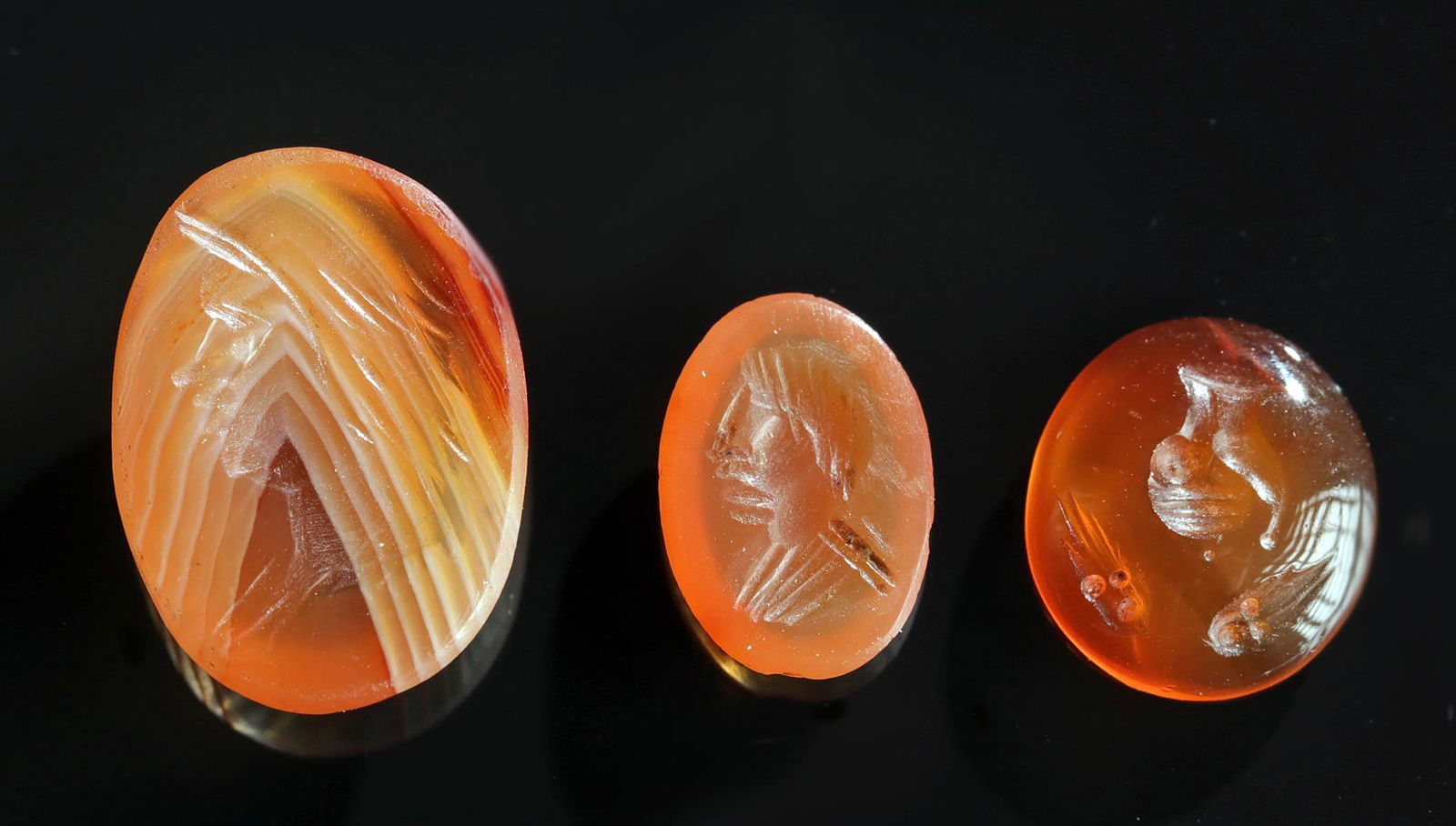 Beautiful Group of Roman Carnelian Intaglios (3): **Originally Listed At $600** Roman, Imperial Period, ca. 1st to 3rd century CE. A group of three gorgeous intaglios carved carnelian of beautiful vermilion hues. The largest intaglio features an eleg