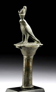 Published Egyptian Bronze Standard Finial Horus Falcon: Egyptian, Late Dynastic, 712 to 343 BCE. A cast bronze standard finial depicting Horus as a falcon wearing the Double Crown fronted by a uraeus and standing upon a plinth atop a papyrus column that