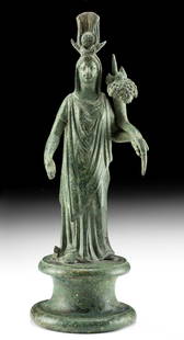 Exhibited Romano-Egyptian Bronze Isis-Fortuna: Egypt, Romano-Egyptian, ca. 2nd century CE. A stunning cast bronze deity with attributes of two primary goddesses of the Hellenistic world, Isis and Fortuna (Greek Tyche). The goddess dons an