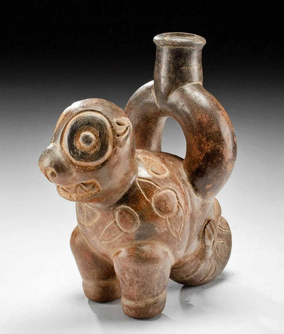 Rare Chavin Redware Stirrup Vessel - Jaguar: Pre-Columbian, North Coast Peru, Chavin 900 to 500 BCE. A hand-built redware stirrup effigy vessel of a zoomorphic feline form. A thick short tail and two stumpy front legs support the rounded body an