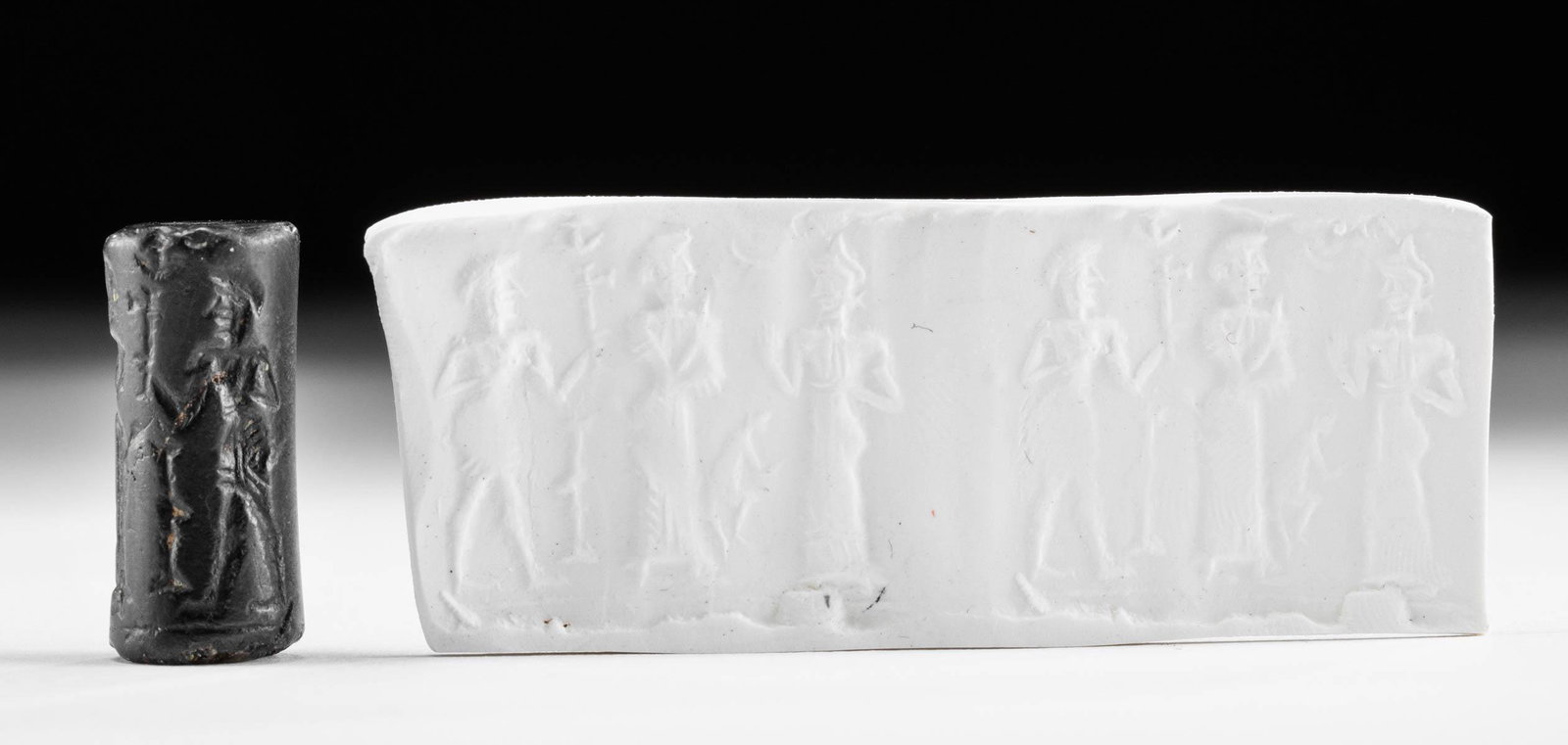 Old Babylonian Hematite Cylinder Seal w/ Figures: Ancient Near East, Mesopotamia, Babylon, Old Babylonian period, ca. early 2nd millennium BCE. A tall and slender cylinder seal carved from rich black hematite with a suspension hole drilled lengthwise