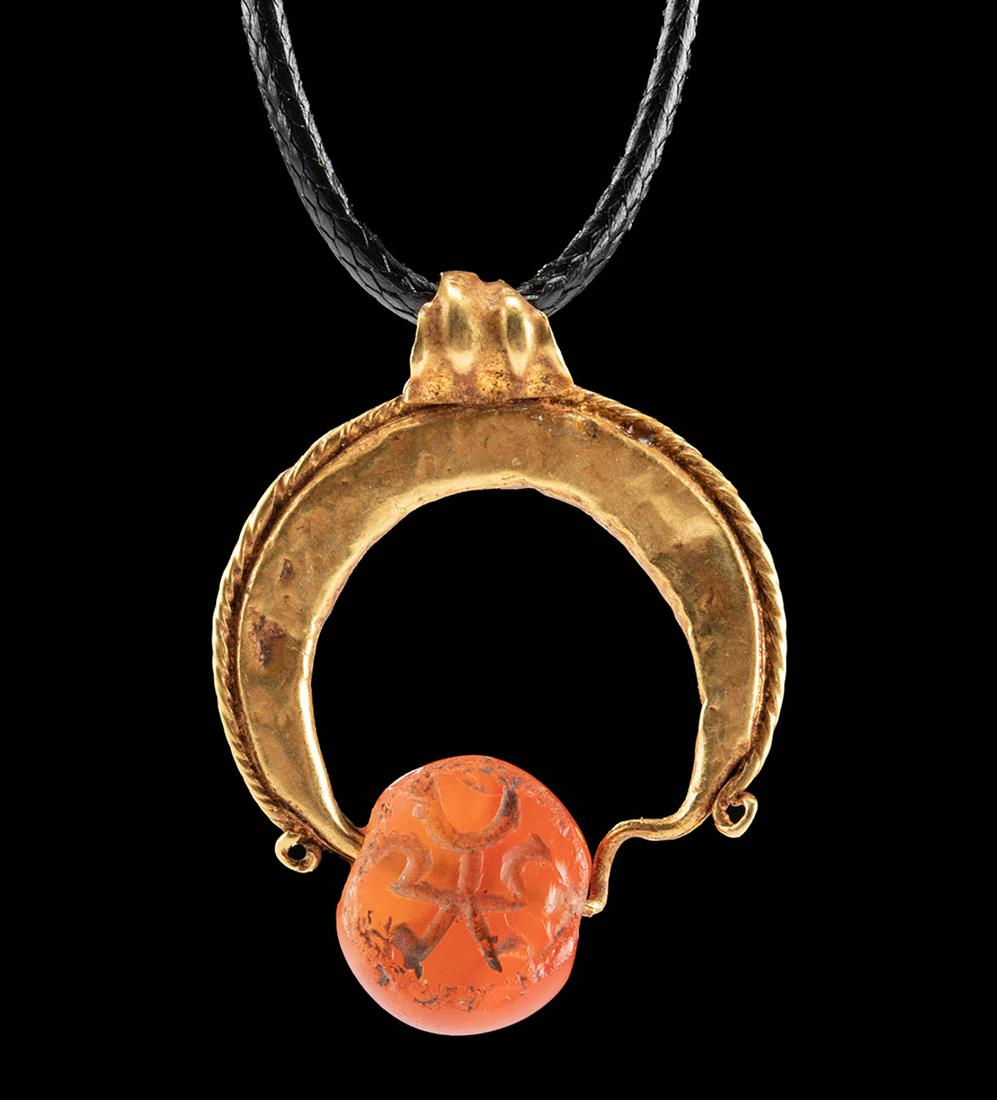 Sassanian Gold Lunate Pendant w/ Carnelian Stamp Seal: Ancient Near East / Central Asia, Sassanian (Sasanian / Sassanid) Empire, ca. 5th to 6th century CE. A gorgeous and wearable pendant made from a hammered sheet of 79% gold (equivalent to 18K+). The lu