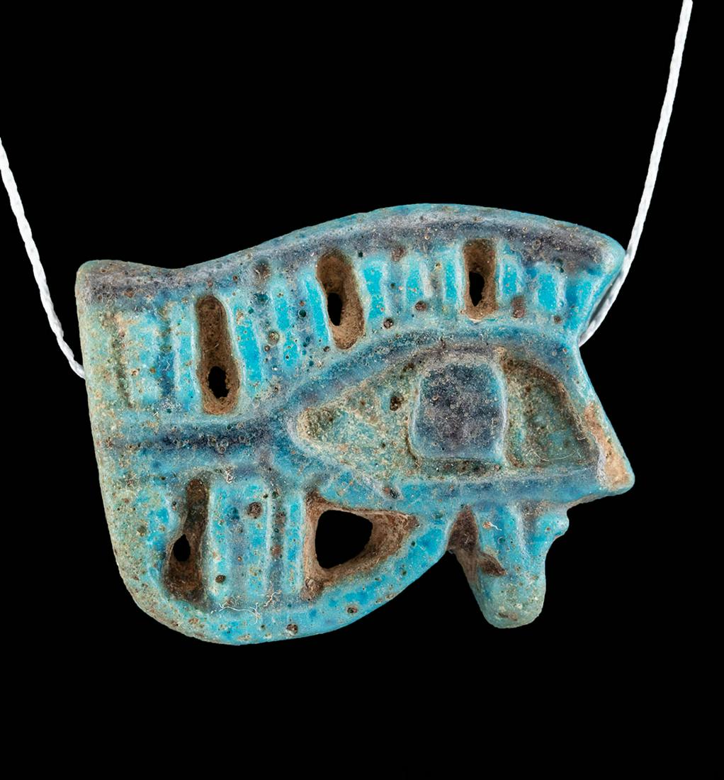 Egyptian Glazed Faience Wadjet Eye Pendant: **First Time At Auction** Ancient Egypt, Third Intermediate Period, 21st to 25th Dynasty, ca. 1070 to 664 BCE. A mold-formed faience amulet depicting a wadjet (or wedjat, "Eye of Horus"), an ancient o