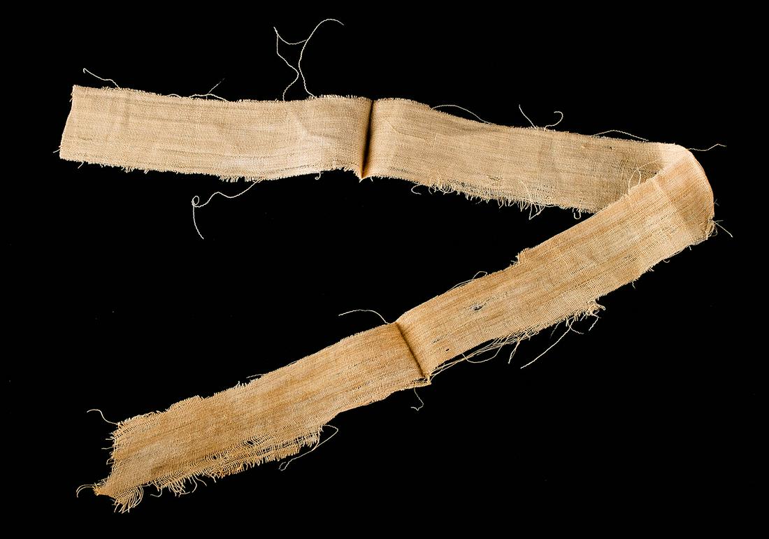 Egyptian Late Dynastic Mummy Wrapping Long Section: **First Time At Auction** Ancient Egypt, Late Dynastic Period, 26th to 31st Dynasty, ca. 664 to 332 BCE. A long section of a mummy wrapping; a textile piece of interwoven fibrous threads. The cloth is