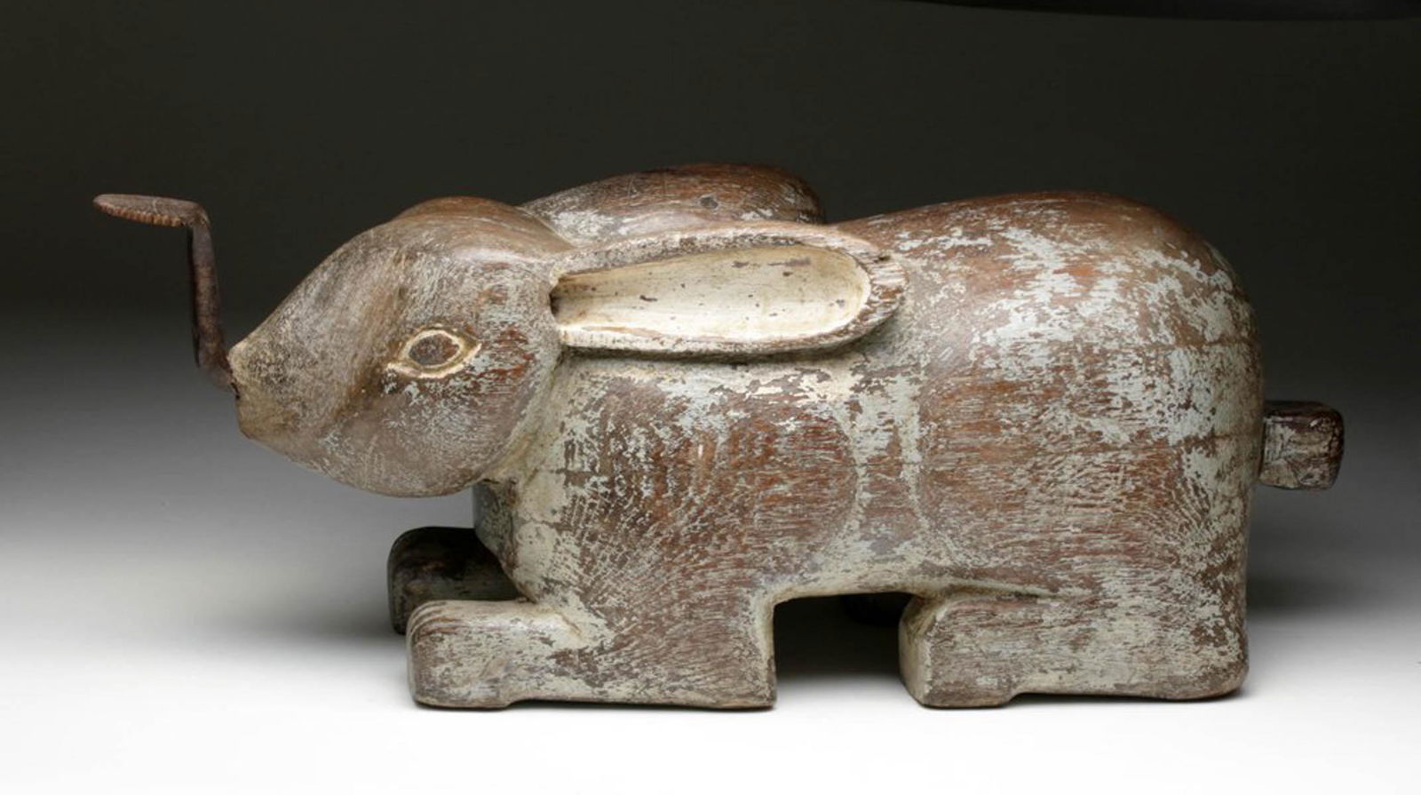 Thai Rabbit Shaped Coconut Grater - Blue & Cream: Southeast Asia, Thailand, ca. late 19th to early 20th century CE. Called a "coconut rabbit", this grater is carved from wood and fitted with a long metal grater extending from its mouth. This example