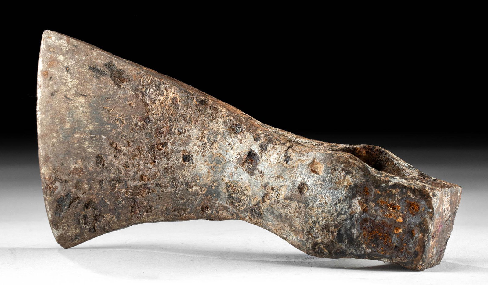9th C. Viking Forged Iron Axe Head Stocky Butt: Northern Europe, Scandinavia, Viking or Norse culture, ca. 9th to 11th century CE. A forged-iron axe head with a stocky butt end, a circular socketing shaft with protruding points along the upper and 