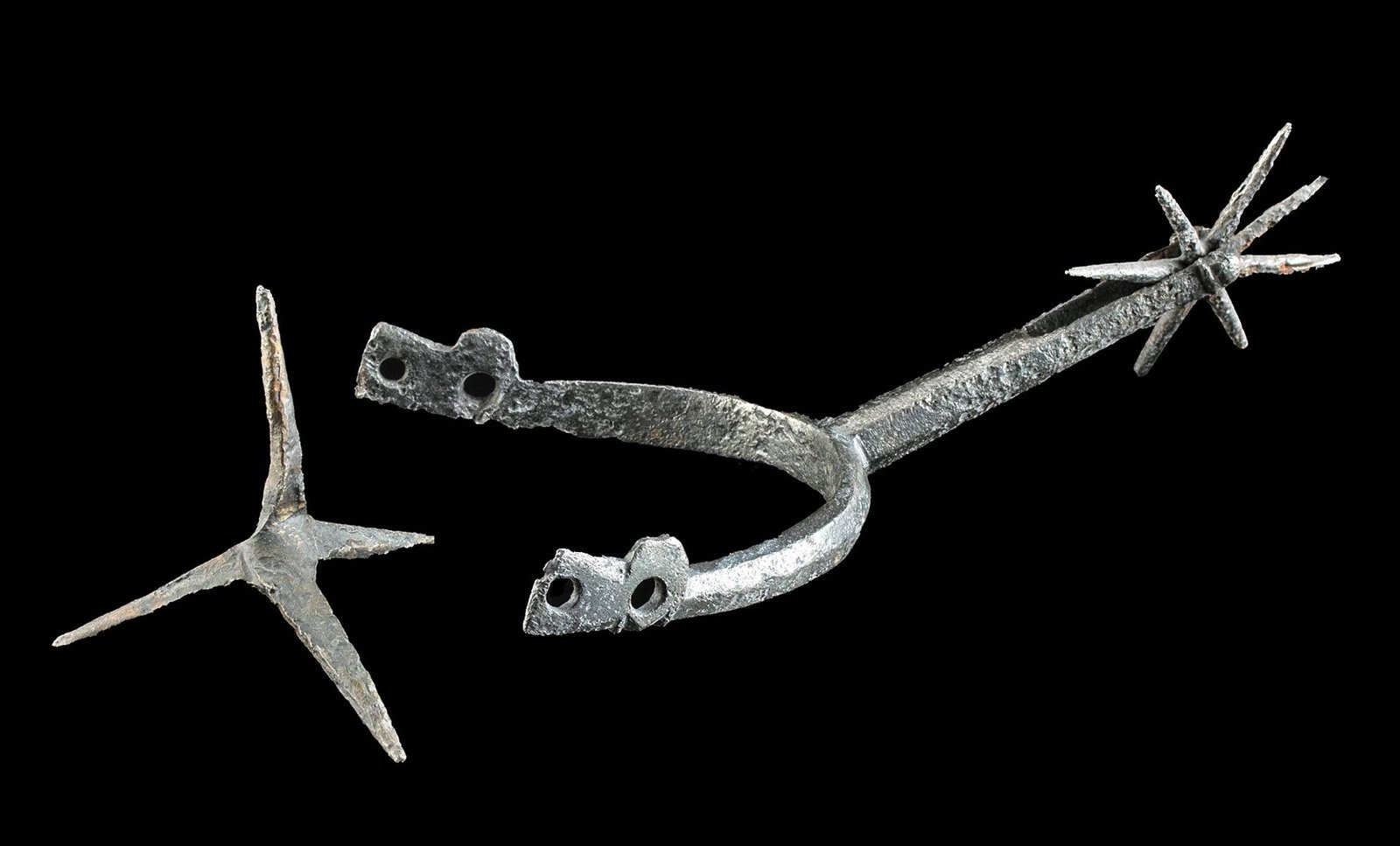 11th C. Medieval European Iron Spur + Caltrop: Western Europe, England or Germany, Medieval period, ca. 1200 to 1400 CE. Two cast iron tools with pointed spikes, a spur and a caltrop. The spur is comprised of a spiked rowel held within a long shan