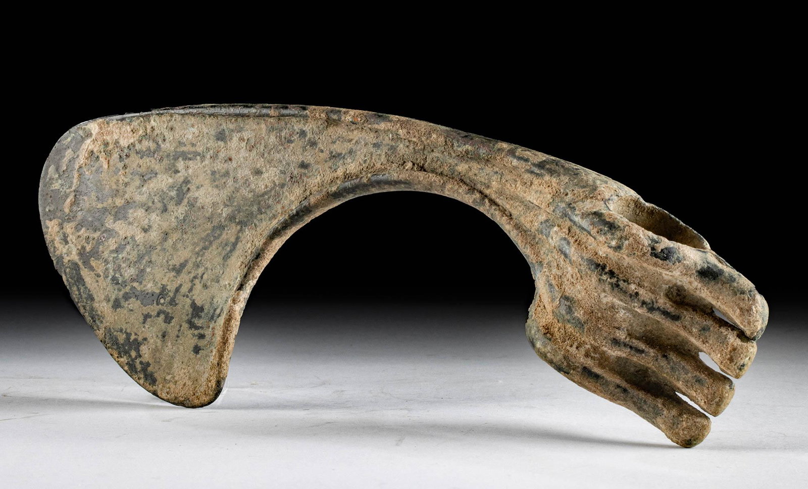 Luristan Bronze Axe Head - Curved Blade, Ribbed Shaft: Ancient Near East, Northwestern Iran, Luristan, ca. 1000 to 600 BCE. A cast bronze axe head with a dramatically curved blade that widens to a broad cutting edge. The socket is narrow and tubular with 