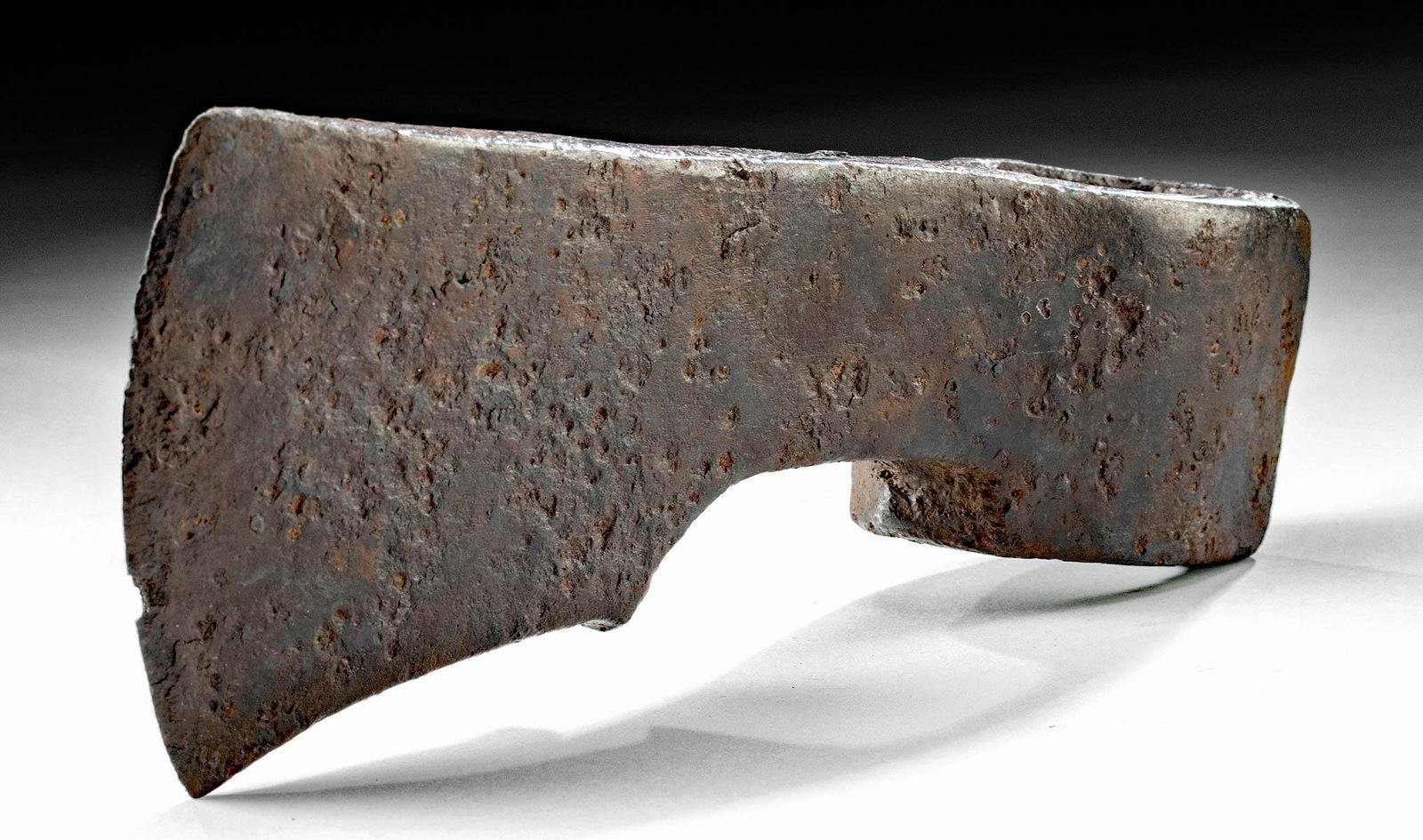 Impressive 8th C. Viking Iron Axe Head: Northern Europe, Scandinavia, Viking or Norse culture, ca. 8th to 10th century CE. A forged-iron axe head bearing a thick butt, an ovoid socketing shaft, a gently tapered neck, and a vertical blade wi