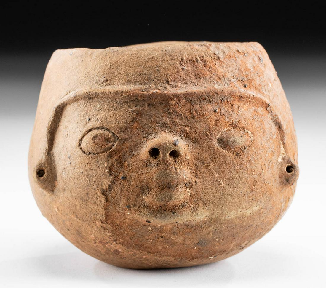 Panamanian Pottery Portrait Jar: **Originally Listed At $50** Pre-Columbian, Central America, Panama, ca. 900 to 1200 CE. A hand-built redware pottery jar with a stylized portrait on the front walls. The almond-shaped eyes flank an u