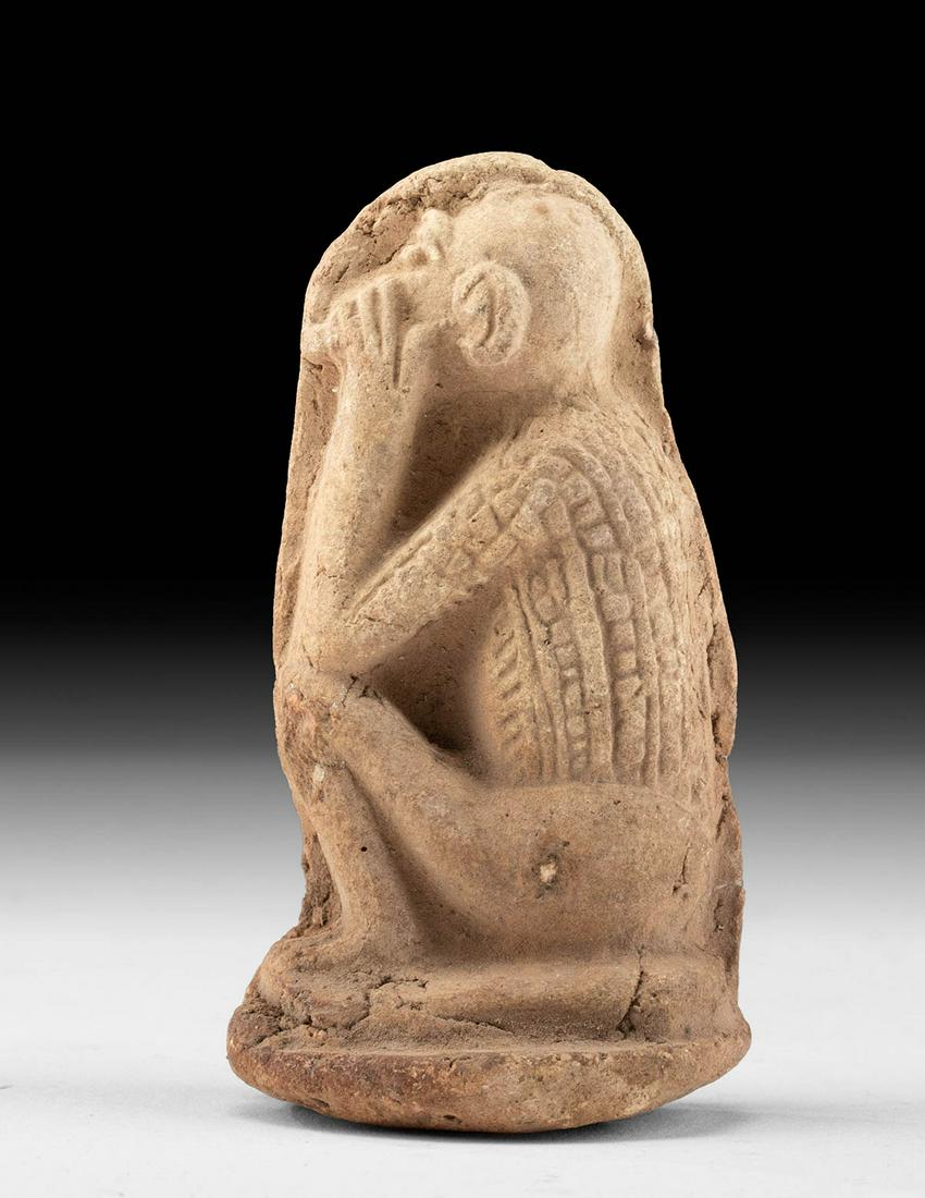 Egyptian Pottery Plaque Figure - Baboon Profile: Ancient Egypt, New Kingdom to Third Intermediate Period, 18th to 25th Dynasty, ca. 1550 to 664 BCE. An interesting mold-formed pottery plaque figure depicting a left-facing baboon. The seated simian h